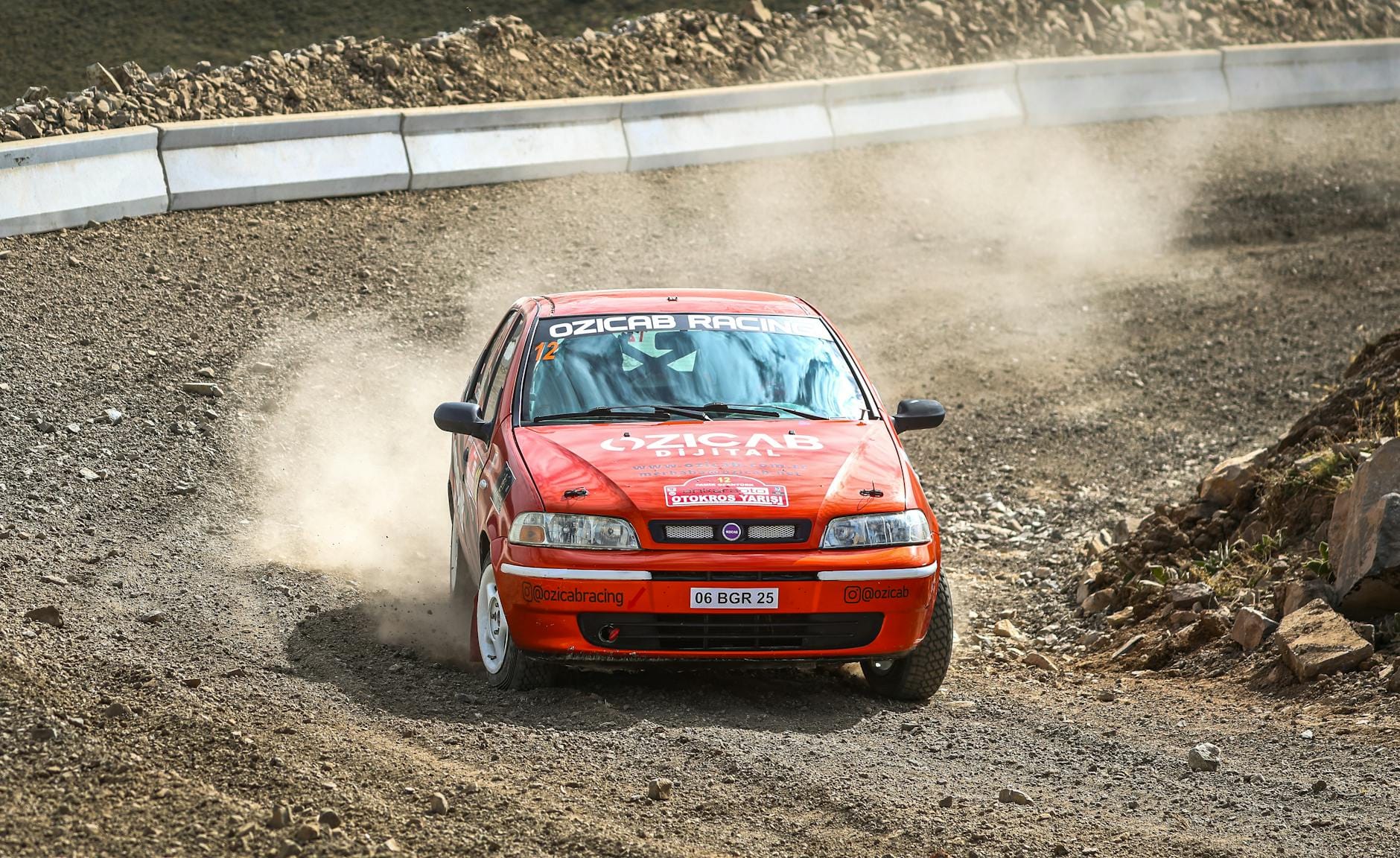 Fiat Palio na szutrowym odcinku rajdu w tumanach kurzu