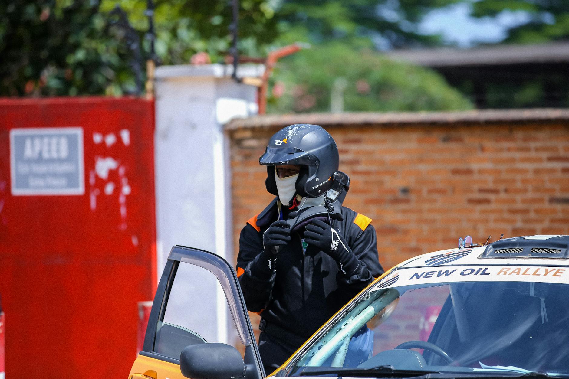 Kierowca rajdowy WRC w kasku szykuje się do startu obok samochodu