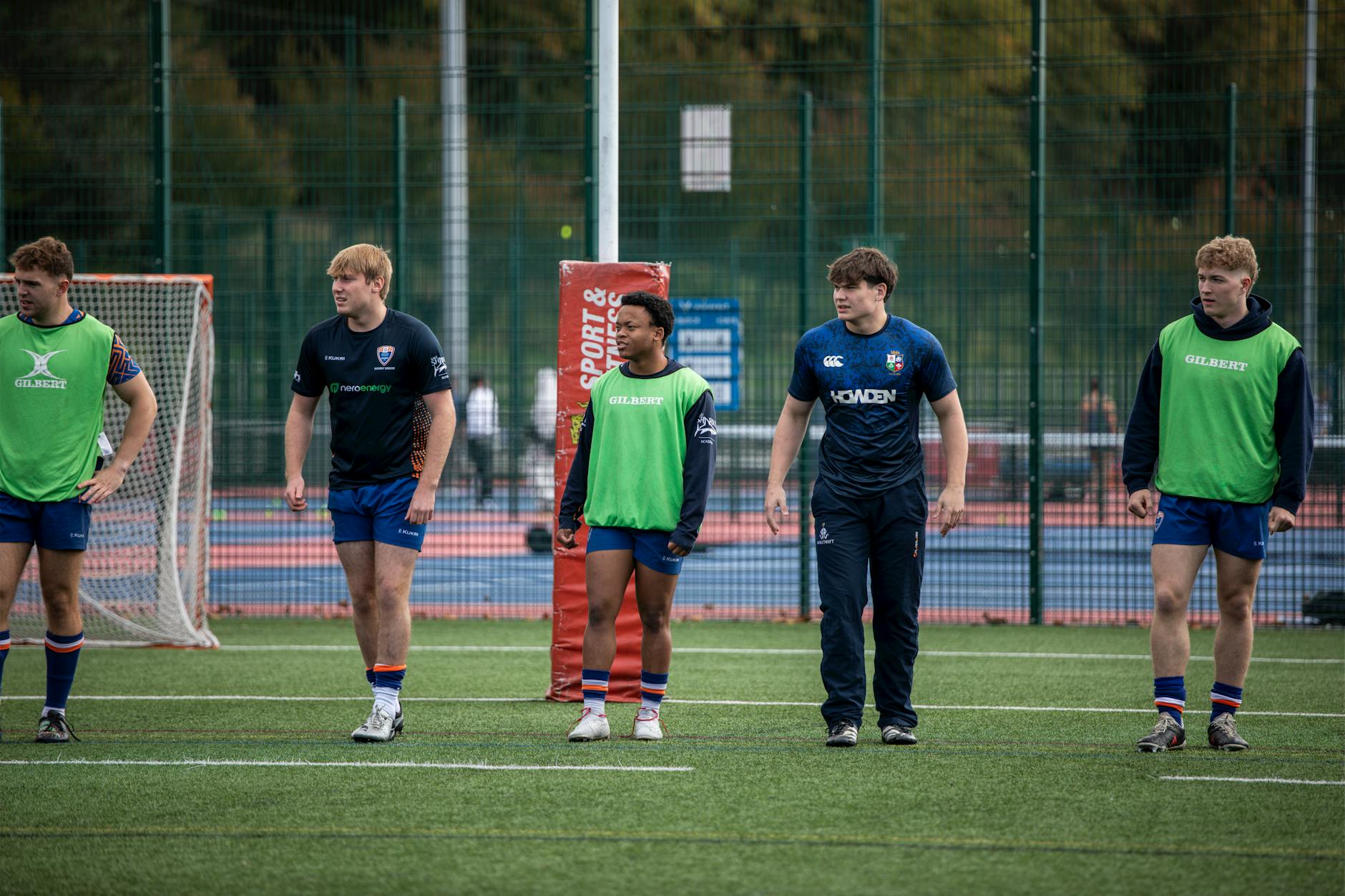 Młodzi zawodnicy rugby trenują na trawiastym boisku