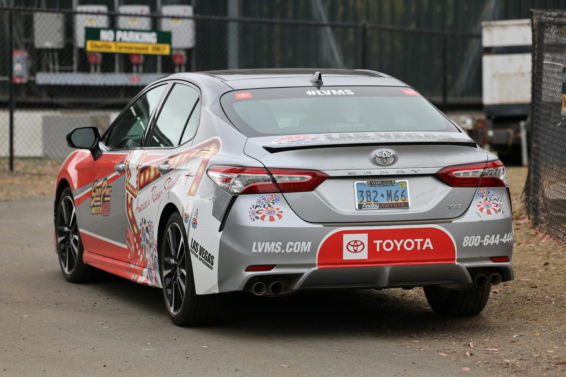 Wyścigowy Toyota Camry z kolorowymi logotypami sponsorów na torze