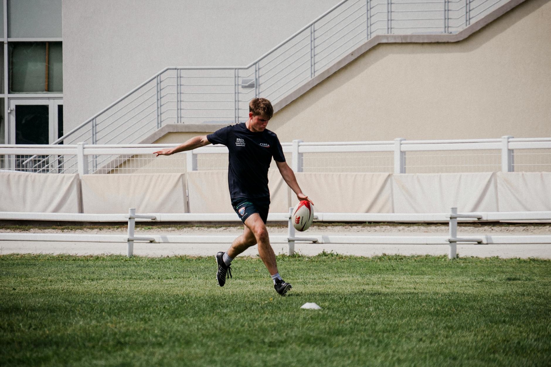 Zawodnik rugby ćwiczący kopnięcie na trawiastym boisku w Budapeszcie