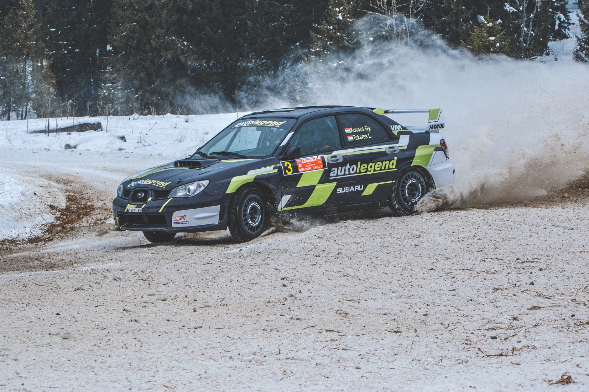 Subaru Impreza w rajdzie, drift na ośnieżonej leśnej trasie